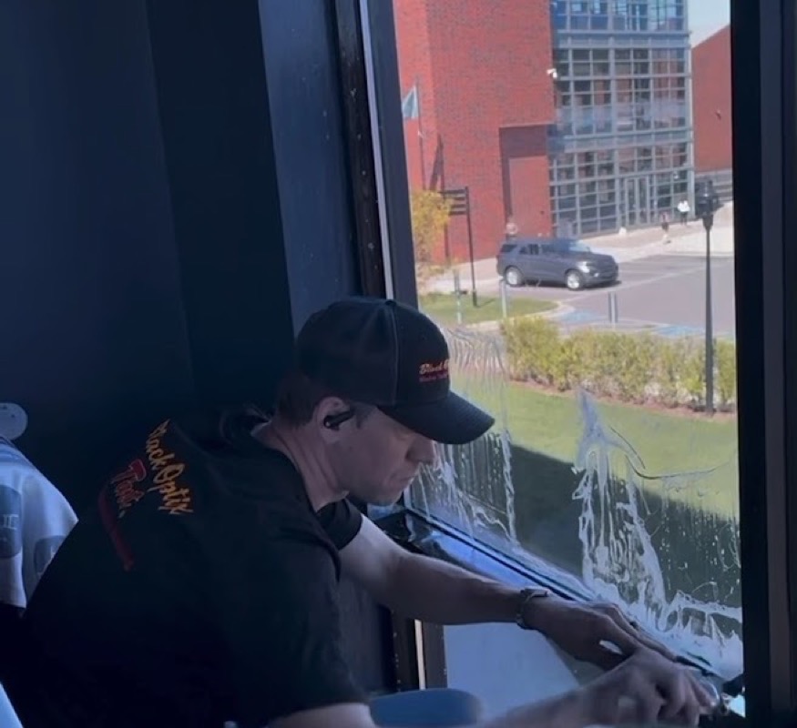Black Optix Tint installer squeegeeing window film during a tint installation in Charlotte NC